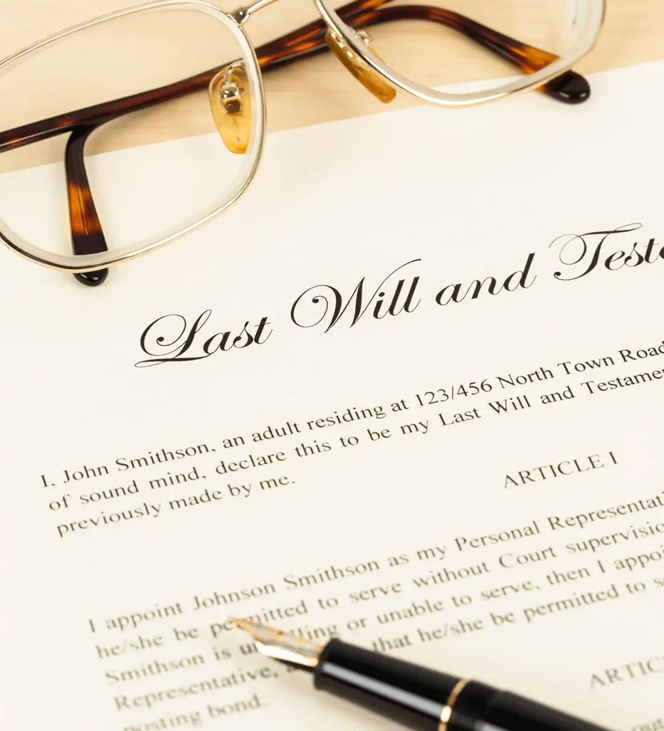 Glasses and a fountain pen on top of a Last Will and Testament.